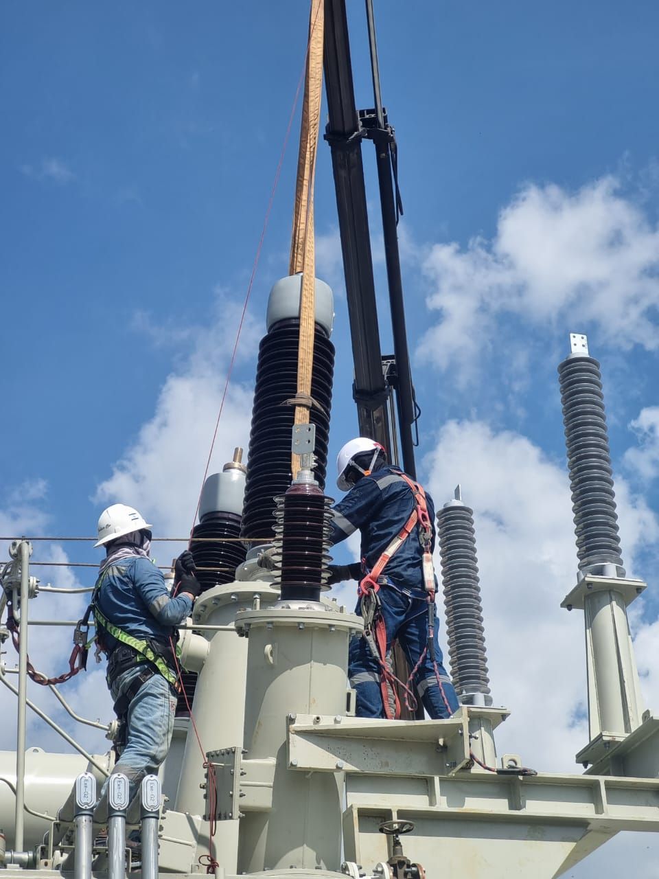 Técnicos trabajando en bujes de alta tensión